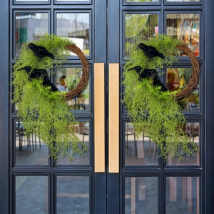 Halloween wreath with green foliage and black crows on a natural grapevine ring