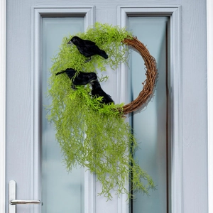 Halloween wreath with artificial greenery and black crows on a natural rattan base