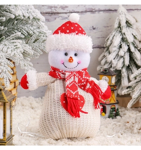 Close-up of a festive knitted snowman drawstring gift bag with a cozy holiday scene