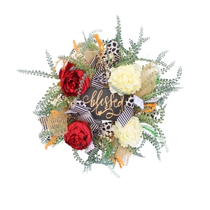 Floral wreath with red and cream artificial flowers and a black blessed wooden sign