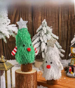 Détail d'ornements sapin de Noël en peluche avec socle en bois dans un décor enneigé