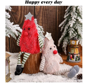 Close-up of plush Christmas tree dolls with striped long legs and sequin stars