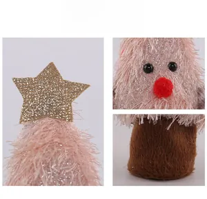 Détail du décor sapin de Noël en peluche rose avec étoile dorée et paillettes argentées