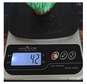 Détail d'une décoration de sapin de Noël en tricot pesant 42g sur une balance