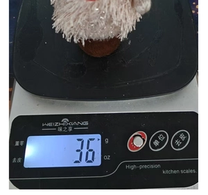 Figurine de sapin de Noël en peluche pesant environ 36g sur une balance digitale