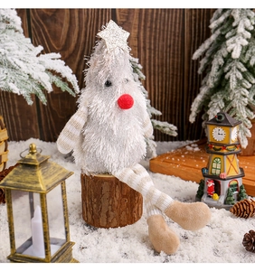Detail of plush Christmas gnome with white fur, golden star, and wooden stump base décor