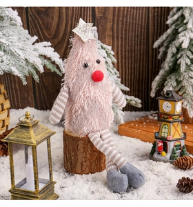 Pink plush Christmas tree figurine with long striped legs sitting on a rustic wood base