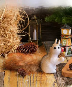 Detailed close-up of a plush squirrel ornament holding a pinecone on a rustic wooden desk