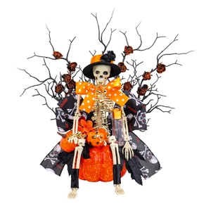 Halloween skeleton sitting on pumpkin with black branches and orange glitter roses decoration