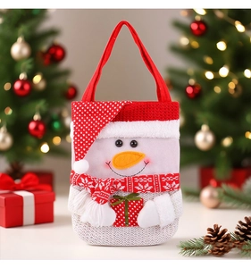 Détail d'un sac cadeau bonhomme de neige en tricot avec écharpe rouge pour Noël