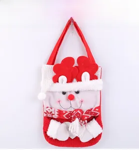 Détail d'un sac cadeau de Noël tricoté avec bonhomme de neige en 3D et écharpe rouge