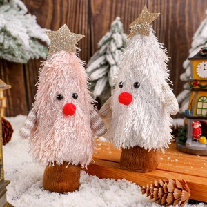 Figurines de sapin de Noël en peluche rose et blanc avec étoiles sur une table de fête