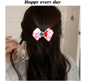 Detalle de lazo para el pelo de Halloween con manchas de sangre y ojo sobre cabello oscuro