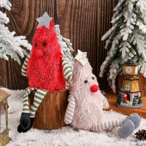 Cute Christmas plush tree dolls with long legs on snow background for holiday decoration