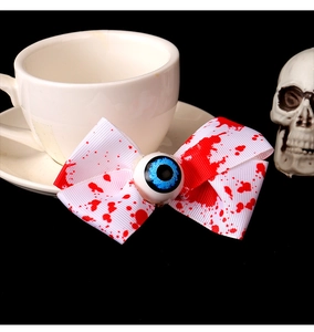 Detalle del lazo para el pelo de Halloween con manchas de sangre roja y ojo azulado