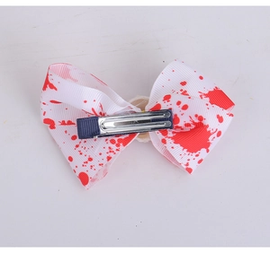 Detalle de lazo para el pelo de Halloween con manchas de sangre roja y pinza metálica fuerte
