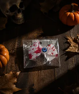 Detalle de lazo de Halloween con manchas de sangre y ojo azul en bolsa transparente