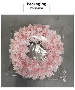 Makro-Detail eines weichen rosa Plüsch-Weihnachtskranzes in schützender Klarsicht-Plastiktüte