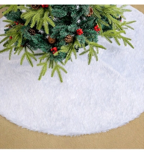 Détail de la jupe de sapin de Noël en peluche blanche douce sous des branches de sapin