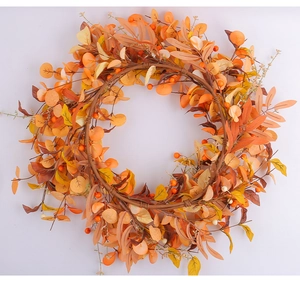 Dettaglio macro di ghirlanda autunnale con bacche arancioni e foglie di acero artificiali