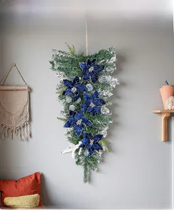 Teardrop Christmas swag with blue poinsettias and silver glitter on green pine needles