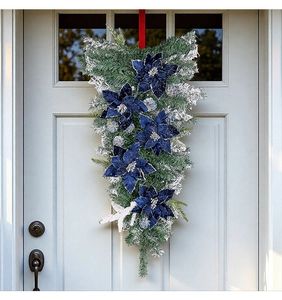 Close-up of blue velvet poinsettia swag with silver glitter on elegant white door