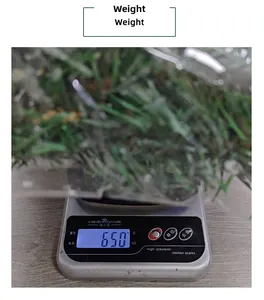 Detailed view of artificial Christmas pine garland weighing 650g on a digital scale