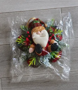 Vue détaillée de la décoration Père Noël avec épines de pin et baies sous emballage