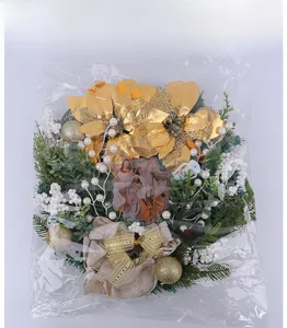 Detail of Christmas wreath with golden leaves, white berries, and a religious card focal point
