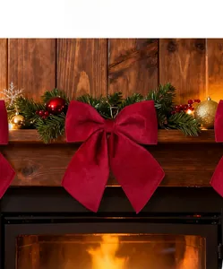 Detailed view of a large red velvet festive bow decorating a warm Christmas fireplace