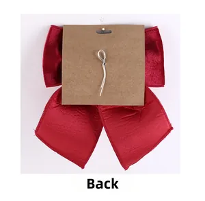 Back view of red velvet bow with silver twist tie and kraft paper card for New Year