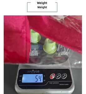 Detailed view of red fabric gift bag containing green capsules on a digital scale