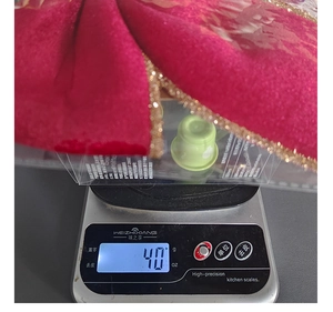 Detail view of a 40g red velvet festival bow decoration on a scale for weight display