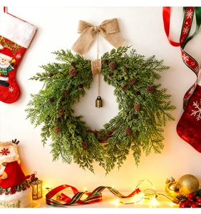 Detail of Christmas pine cone wreath with burlap bow and a bronze bell hanging on the door