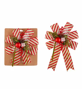 Detailed view of Christmas bow with red berries, pine cones and green foliage accents