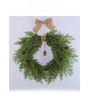 Macro detail of Christmas wreath with natural pine cones, burlap bow, and a small bell