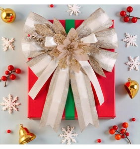 Dettaglio di un grande fiocco natalizio bianco glitterato su una scatola regalo rossa