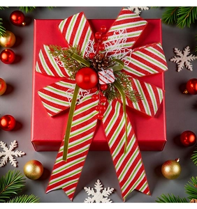 Macro di fiocco natalizio a righe con pigne e bacche su una confezione regalo rossa