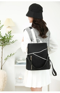 Detail of minimalist black backpack with white curved lines and waterproof nylon fabric