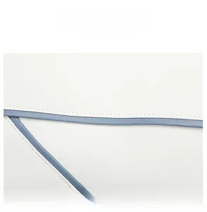 Close-up of white lychee textured bag featuring blue contrast edge and fine stitching