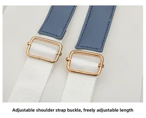Detail of adjustable shoulder strap with gold metal buckle on blue and white bag