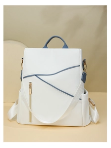 Detail of high-density cream fabric with blue leather trim on a minimalist travel backpack