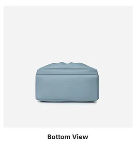 Detailed bottom view of light blue oxford fabric backpack showing neat stitching and square base