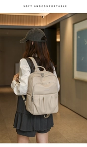 Model wearing a minimalist beige oxford backpack with large capacity and soft texture