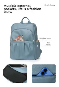 Detail view of morandi blue oxford cloth backpack showing side pocket and inner lining