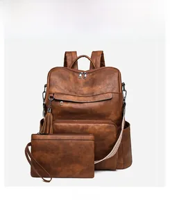 Brown vintage faux leather backpack set with tassel and matching wristlet clutch