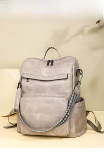 Detailed view of taupe PU leather backpack with tassel and geometric woven strap