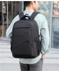 Rear view of a man wearing a black large capacity business laptop backpack outdoors