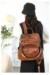 Detailed view of brown vintage laptop backpack with tassel and patterned strap