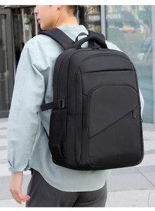 Detail of a large black business backpack with mesh side pockets and padded shoulder straps